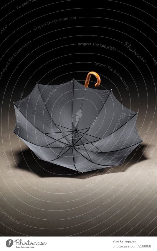 Alter Regenschirm altmodisch altehrwürdig offen aufgeklappt Menschenleer Haken Handgriff Etage auf den Kopf gestellt Schirm schwarz Objektfotografie