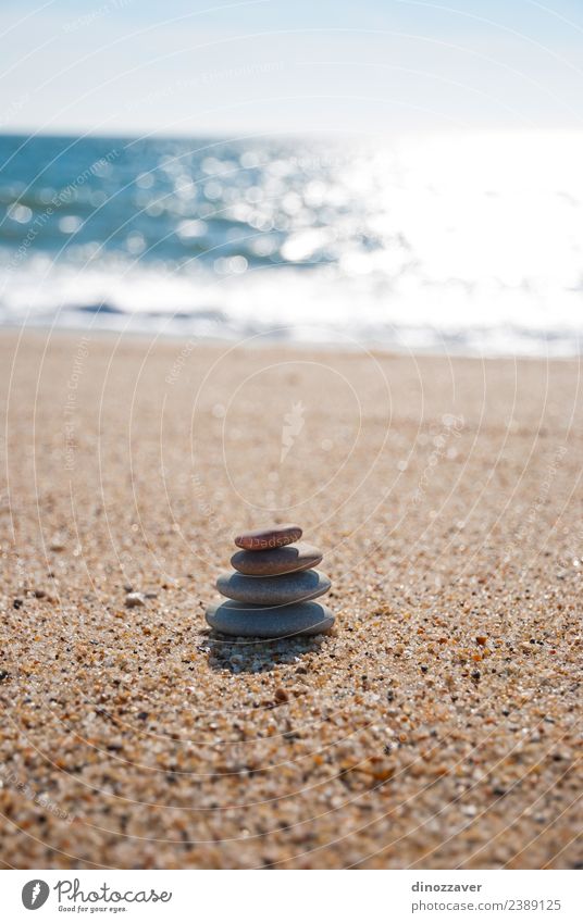 Steine stapeln sich auf dem Sand. Wellness harmonisch Erholung Meditation Spa Sommer Strand Meer Natur Himmel Horizont Felsen Küste natürlich blau schwarz weiß