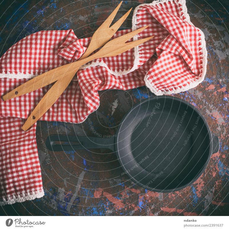 leere runde schwarze gusseiserne Bratpfanne Topf Pfanne Gabel Tisch Küche Holz Metall Stahl alt Sauberkeit rot weiß Hintergrund Lebensmittel Kochgeschirr braten