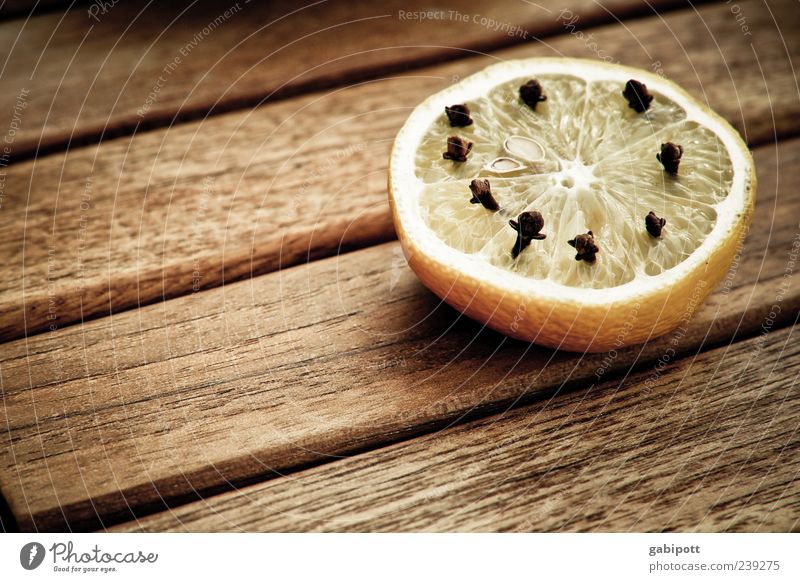 Gut gegen Mücken Lebensmittel Frucht Kräuter & Gewürze Zitrone Gewürznelke Tisch Duft sauer braun gelb Erholung Idylle Häusliches Leben Holzplatte Holztisch