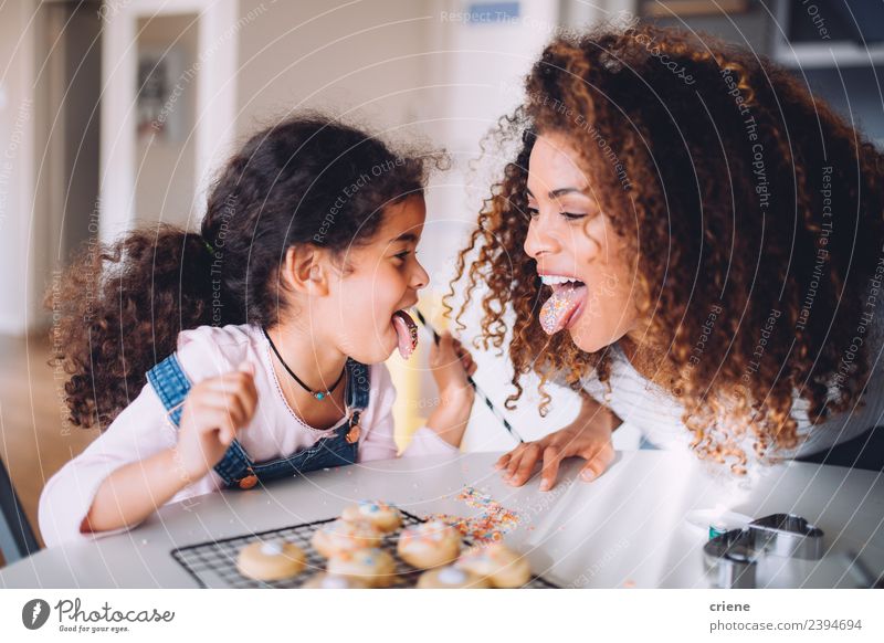 Mutter und Tochter, die Spaß daran haben, gemeinsam Kekse zu essen. Essen Freude Glück Küche Kind Frau Erwachsene Familie & Verwandtschaft Kindheit Lächeln