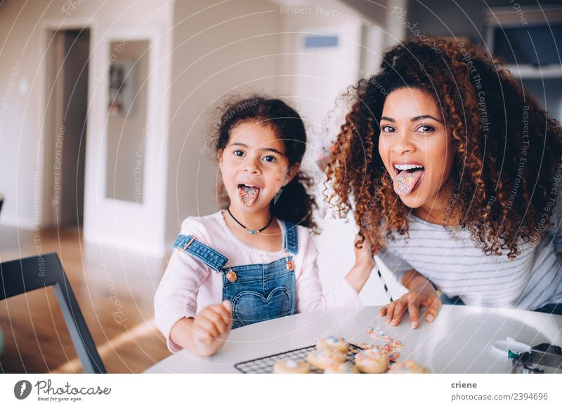 Mutter und Tochter ziehen lustiges Gesicht in der Küche Essen Freude Glück Kind Frau Erwachsene Familie & Verwandtschaft Kindheit Lächeln Liebe Fröhlichkeit