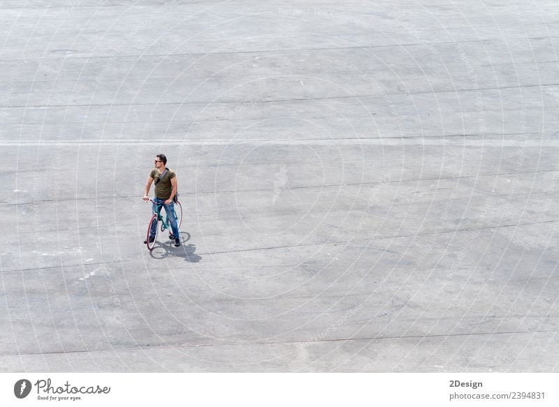 Junger Mann steht mit seinem Fahrrad auf einem Platz. Lifestyle Leben Ferien & Urlaub & Reisen Tourismus Mensch maskulin Jugendliche Erwachsene 1 30-45 Jahre