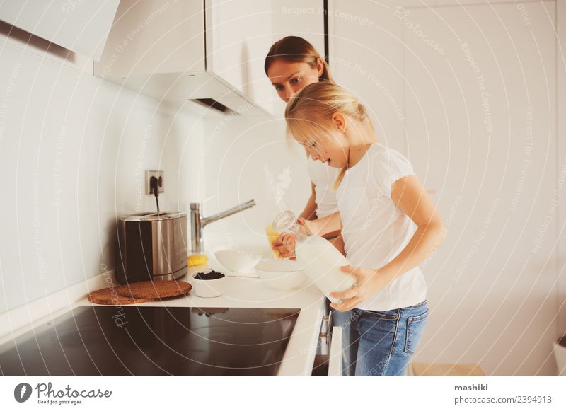 Mutter beim Frühstück mit der kleinen Tochter zu Hause Lifestyle Freude Glück Küche Kind Erwachsene Familie & Verwandtschaft Lächeln Umarmen Zusammensein modern