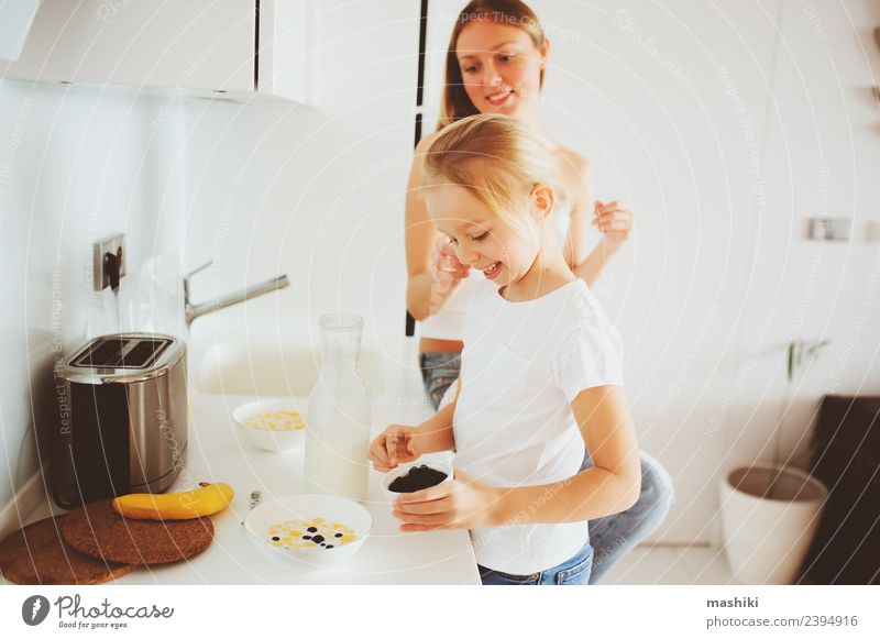 Mutter beim Frühstück mit der kleinen Tochter Lifestyle Freude Glück Küche Kind Erwachsene Familie & Verwandtschaft Lächeln Umarmen Zusammensein modern weiß