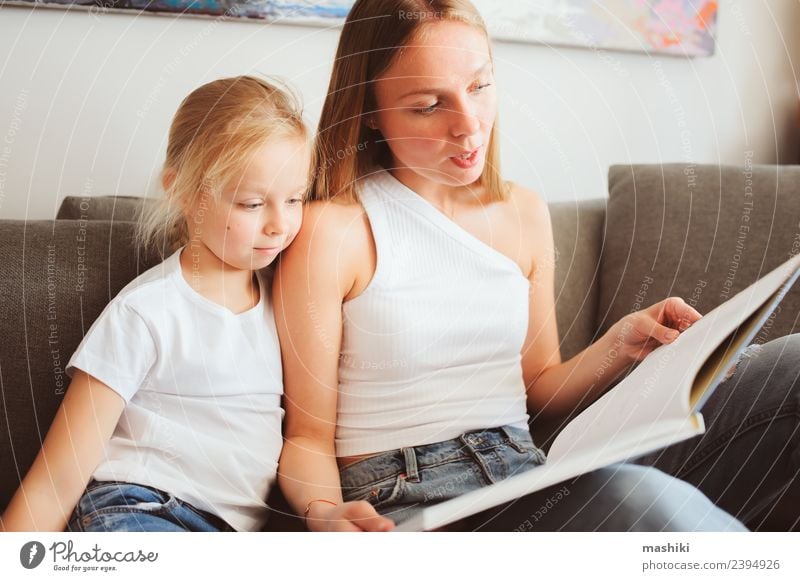 Mutter liest der Tochter ein Buch vor. Lifestyle Freude Erholung Spielen lesen Schlafzimmer Kleinkind Eltern Erwachsene Familie & Verwandtschaft Lächeln