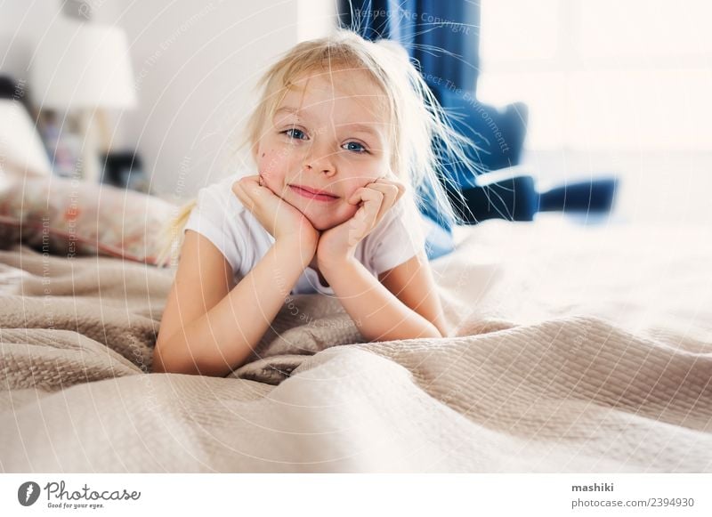 süßes glückliches Kleinkind Mädchen auf dem Bett Lifestyle Freude Glück Erholung Spielen Schlafzimmer Familie & Verwandtschaft Lächeln schlafen klein lustig