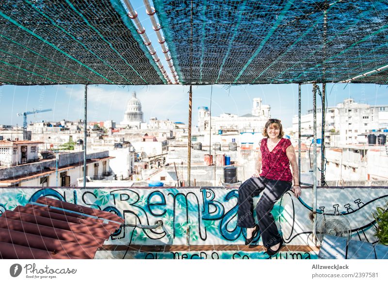 junge Frau sitzt auf einem Dach in Havanna Kuba Kapitol Skyline Aussicht Wohnhaus baufällig Baustelle Blauer Himmel Wolkenloser Himmel Sommer