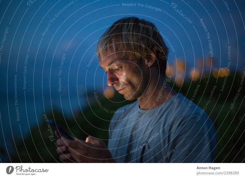 Mann mit Handy Erwachsene 1 Mensch 30-45 Jahre Kommunizieren Blick mehrfarbig Außenaufnahme Textfreiraum links Textfreiraum rechts Abend Starke Tiefenschärfe