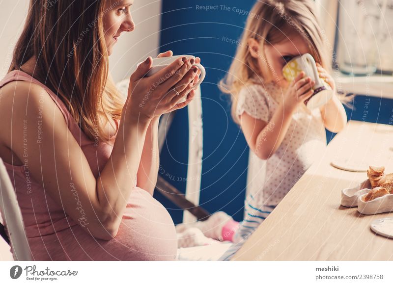 Kleinkind Mädchen mit schwangerer Mutter zu Hause Frühstück Tee Freude Spielen Tisch Küche Kind Baby Eltern Erwachsene Familie & Verwandtschaft blond Lächeln