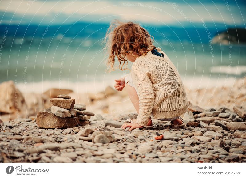 Kind Mädchen spielt mit Steinen am Strand Freude Glück schön Spielen Ferien & Urlaub & Reisen Sommer Meer Himmel Küste Lächeln sitzen klein niedlich blau weiß