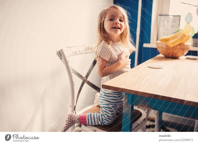fröhliches Kleinkind beim Spielen in der Küche Frühstück Lifestyle Freude Glück schön Gesicht Kind Baby Lächeln lachen sitzen Fröhlichkeit klein modern niedlich