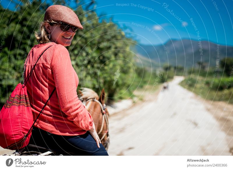junge Frau mit Hut reitet auf Pferd durch die Natur in Trinidad Kuba Sozialismus alt historisch retro old-school altmodisch Außenaufnahme Tag Sommer Sonne
