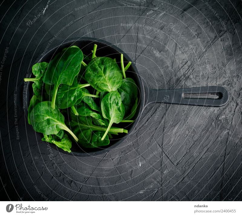 grüne Blätter in einer schwarzen runden Bratpfanne Gemüse Salat Salatbeilage Kräuter & Gewürze Ernährung Vegetarische Ernährung Diät Pfanne Gesunde Ernährung