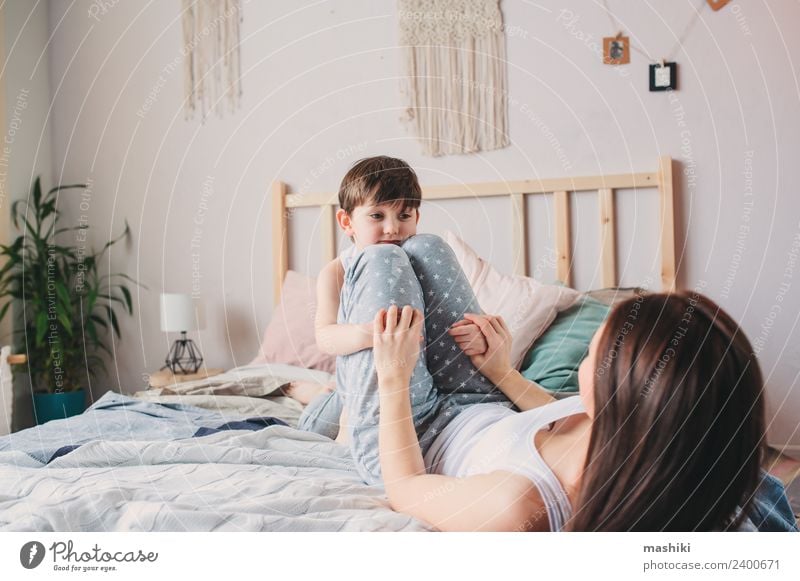 glückliche Mutter und Kind Sohn spielen im Bett Lifestyle Freude Glück Leben Erholung Spielen Schlafzimmer Kleinkind Junge Eltern Erwachsene