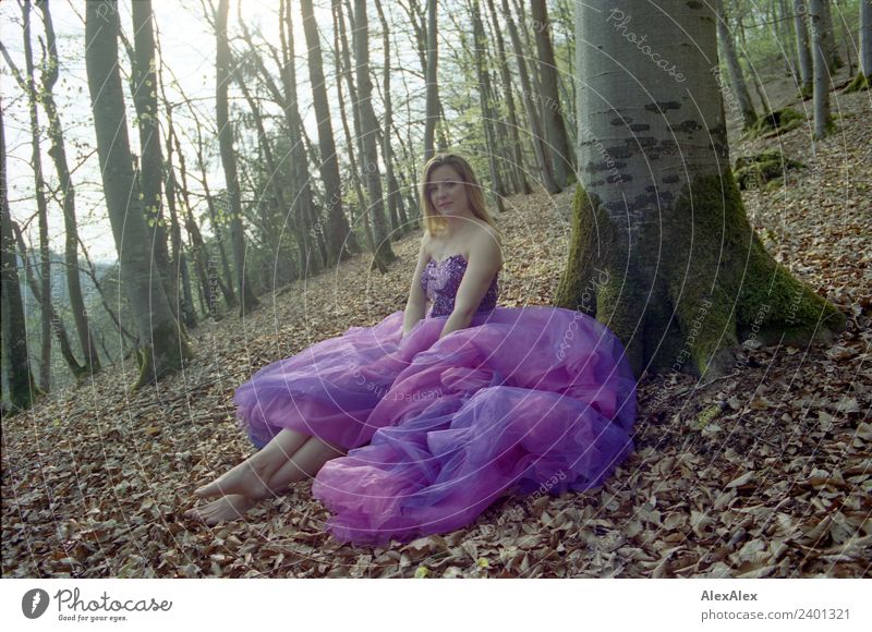Junge, große Frau sitzt in einem lila Brautkleid barfuß an einem Baum im Wald Lifestyle Reichtum elegant Stil Freude schön Erholung Ausflug Sommer Junge Frau