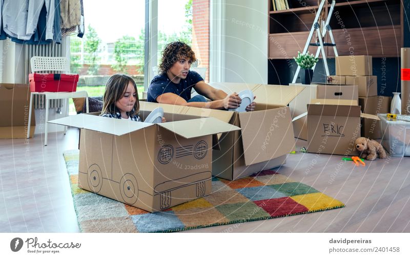 Vater und Sohn spielen mit Pappkartons im Wohnzimmer Teller Lifestyle Freude Glück Erholung Spielen Haus Umzug (Wohnungswechsel) Kind Mensch Junge Mann