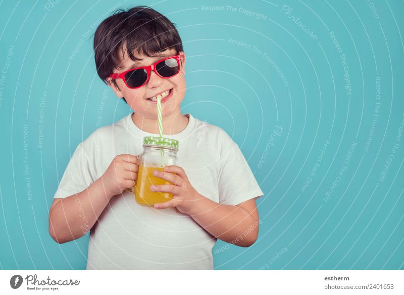 glücklicher Junge trinkt Orangensaft auf blauem Hintergrund Ernährung Getränk trinken Limonade Saft Lifestyle Freude Mensch maskulin Kind Kleinkind Kindheit 1