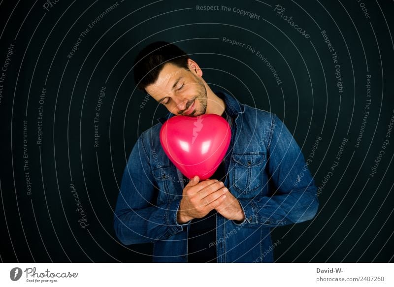 verliebter träumender Mann hält einen herzförmigen Luftballon in den Händen Herz Liebe Romantik Romantiker Verliebtheit Gefühle Farbfoto Valentinstag rot Glück