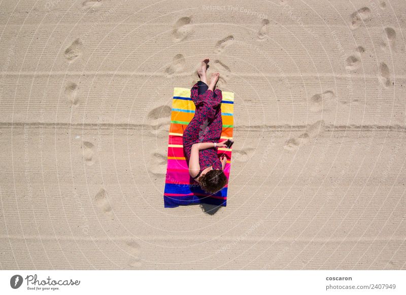 Frau in einem Handtuch am Strand mit Blick auf ein Handy Lifestyle elegant Freude Glück schön Sommer Sonne Sonnenbad Meer Telefon PDA Erwachsene Natur Fluggerät