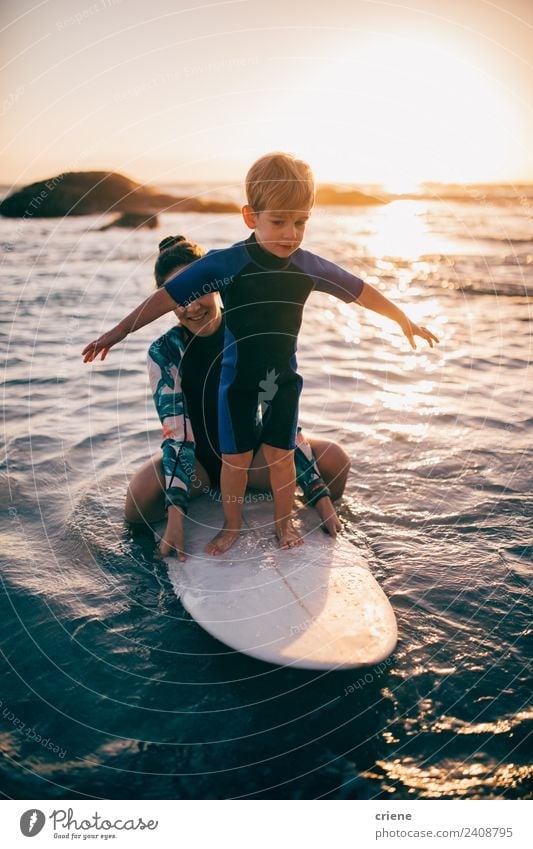 kaukasische Mutter hilft dem Sohn zu lernen, wie man surft. Lifestyle Freude Glück Freizeit & Hobby Ferien & Urlaub & Reisen Sommer Strand Meer Sport Kind