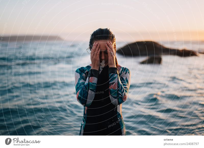 kaukasische Frau im Neoprenanzug bei Sonnenuntergang Meer Erwachsene Hand Felsen brünett nass blau braun Surfen Wasser jung Kaukasier versteckend Hintergrund