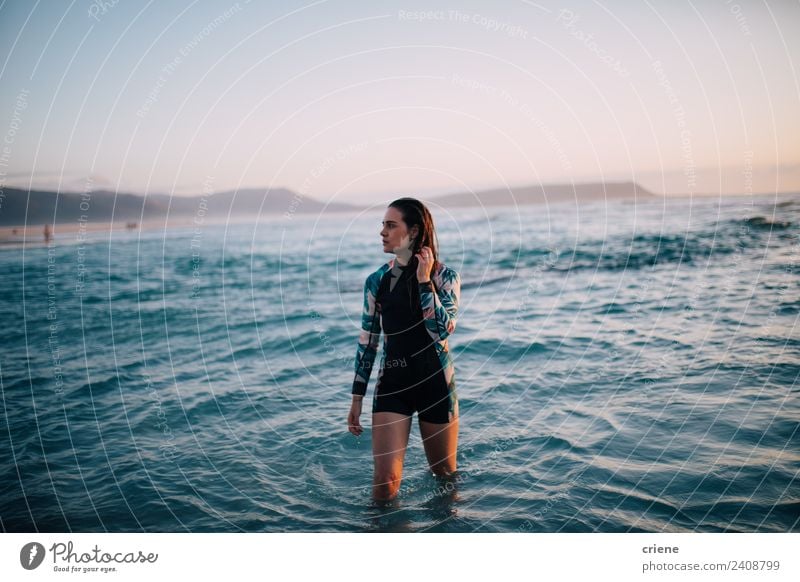 kaukasische Frau geht im Neoprenanzug aus dem Wasser. schön Sommer Sonne Strand Meer Sport Mensch Erwachsene Natur Felsen brünett Denken träumen dünn hell lang