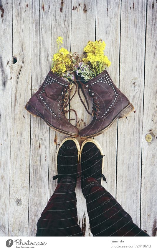 Jemand vor alten Stiefeln, gefüllt mit Blumen. Stil Design Beine Natur Pflanze Wildpflanze Topfpflanze Bekleidung Schuhe Turnschuh Holz Leder dreckig frisch