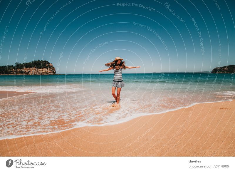 Frau mit Hut und Kleid, die an einem schönen australischen Strand im Strandwasser tanzt. Lifestyle Freude Wellness Leben Wohlgefühl Freiheit Erwachsene 1 Mensch