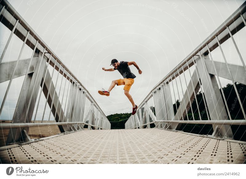 Mann, der auf eine Brücke springt. Lifestyle Leben Ferien & Urlaub & Reisen Ausflug Abenteuer Mensch Erwachsene 1 18-30 Jahre Jugendliche Umwelt Natur