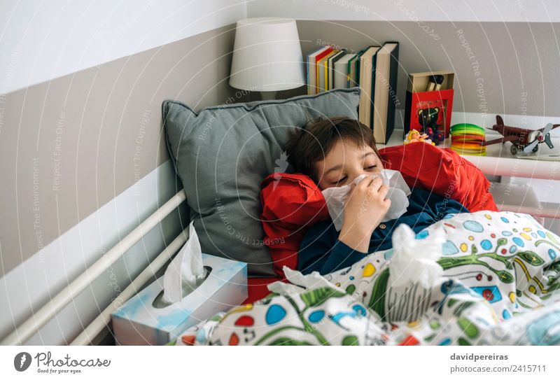 Kaltes Kind auf dem Bett liegend Lifestyle Krankheit Lampe Schlafzimmer Mensch Junge Mann Erwachsene Kindheit Buch Spielzeug authentisch Müdigkeit lügen kalt