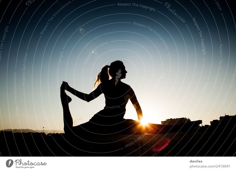 Frau Silhouette während Stretching Sitzung nach Fitness-Sitzung. Gegenlicht während des Sonnenuntergangs. Lifestyle Körper Wellness Leben Wohlgefühl Erholung