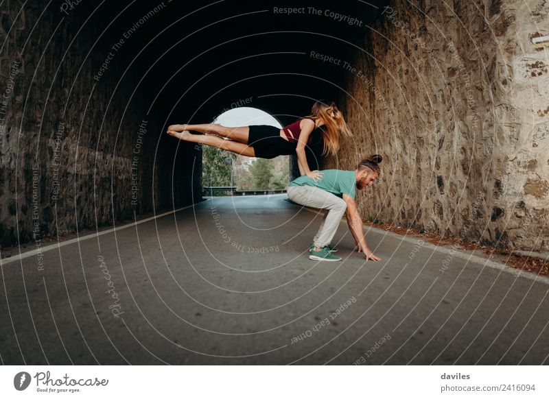 Ein Paar tanzt mitten auf der Straße, in einem Tunnel. Lifestyle Stil schön Sport Frau Erwachsene Mann 2 Mensch 18-30 Jahre Jugendliche Tanzen Stollen T-Shirt