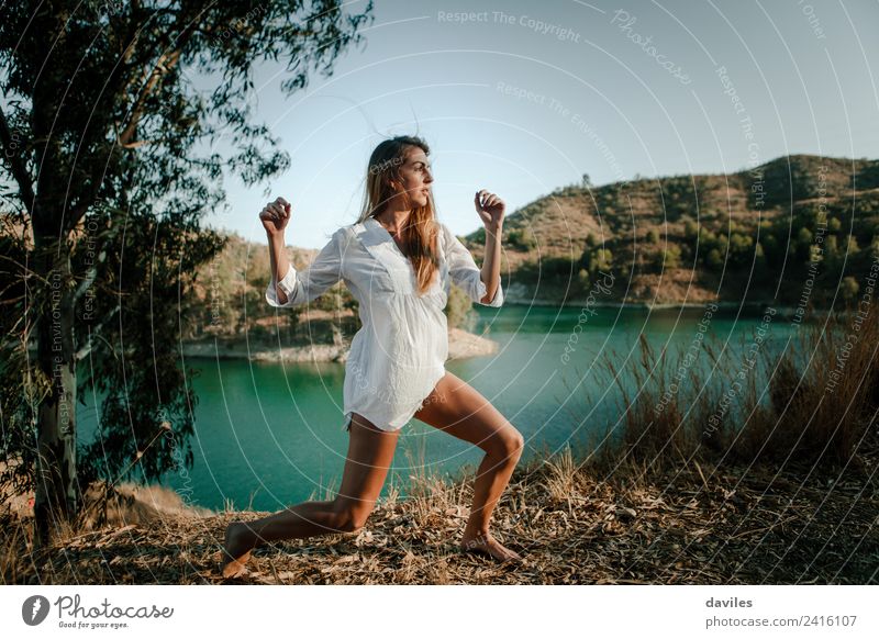 Frau, die in der Natur posiert und einen See im Hintergrund hat. Lifestyle Glück schön Meditation Freiheit Sommer Sonne Berge u. Gebirge Mensch Erwachsene 1