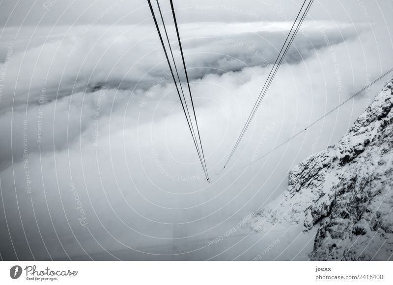Blick nach unten aus einer Seilbahn-Gondel auf die in den Wolken verschwinenden Stahlseile Wetter steil Nebeldecke Höhe grau Erwartung Drahtseil Wolkendecke