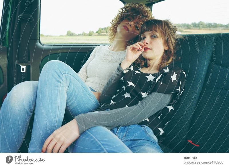 Zwei junge Freunde sitzen zusammen in einem Auto. Lifestyle Stil Ferien & Urlaub & Reisen Tourismus Ausflug Abenteuer Mensch feminin Junge Frau Jugendliche