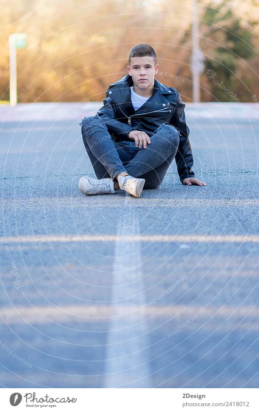 Stylisch lächelnder Teenager, der auf der Straße sitzt. Lifestyle Freude Glück Schulkind Studium PDA Mensch maskulin Junge Junger Mann Jugendliche Erwachsene 1