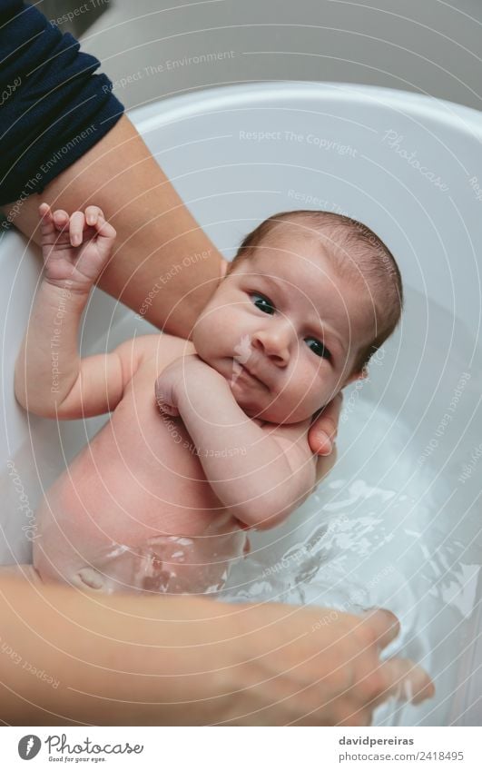 Neugeborenes in der Badewanne, die von ihrer Mutter gehalten wird. Lifestyle schön ruhig Kind Mensch Baby Frau Erwachsene Familie & Verwandtschaft Hand