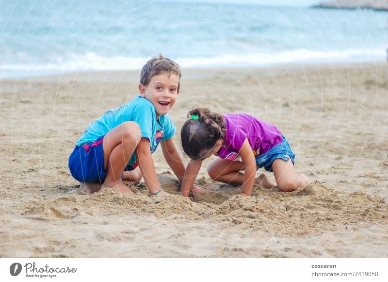 Zwei Kinder beim Graben am Strand Freude Spielen Sommer Meer Baby Junge Paar Sand Lächeln Fröhlichkeit klein Rücken Schürfen Mädchen Kidvacation zwei Wasser Tag