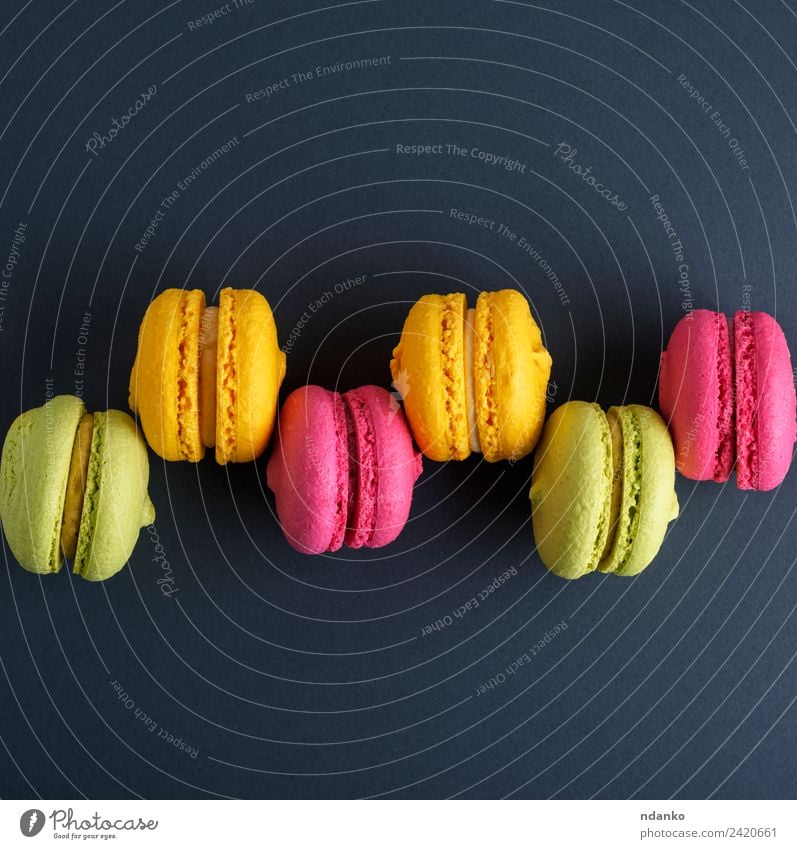 Reihe von mehrfarbigen Kuchen Dessert Süßwaren Essen hell gelb grün rosa schwarz Farbe Macaron Hintergrund Lebensmittel farbenfroh Vanille Französisch Aussicht