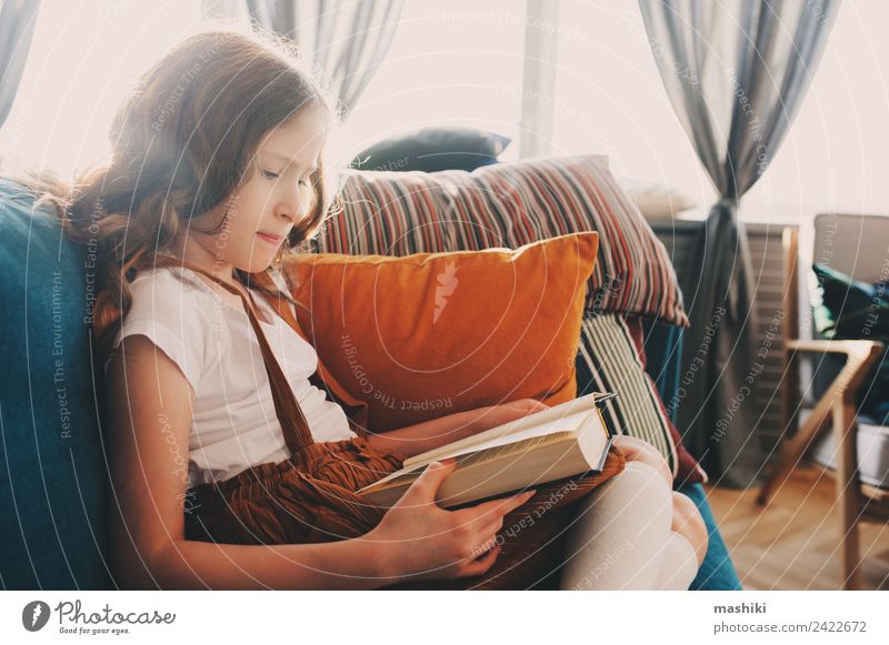 smartes Kind Mädchen liest interessantes Buch Lifestyle Erholung lesen Schule lernen Schulkind Kindheit Bibliothek authentisch klein klug Einsamkeit bequem