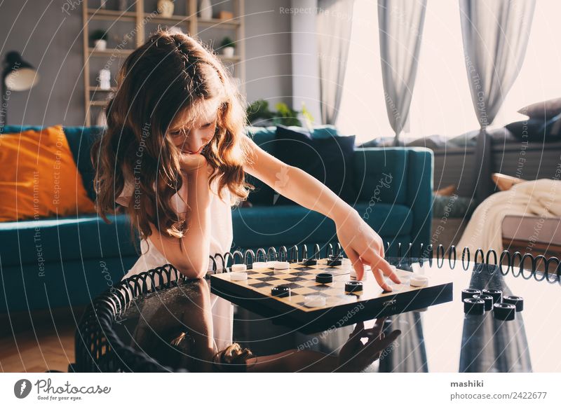 Lifestyle-Aufnahme von einem klugen Kind, das zu Hause Dame spielt. Freizeit & Hobby Spielen Schach Mädchen Eltern Erwachsene Familie & Verwandtschaft Spielzeug