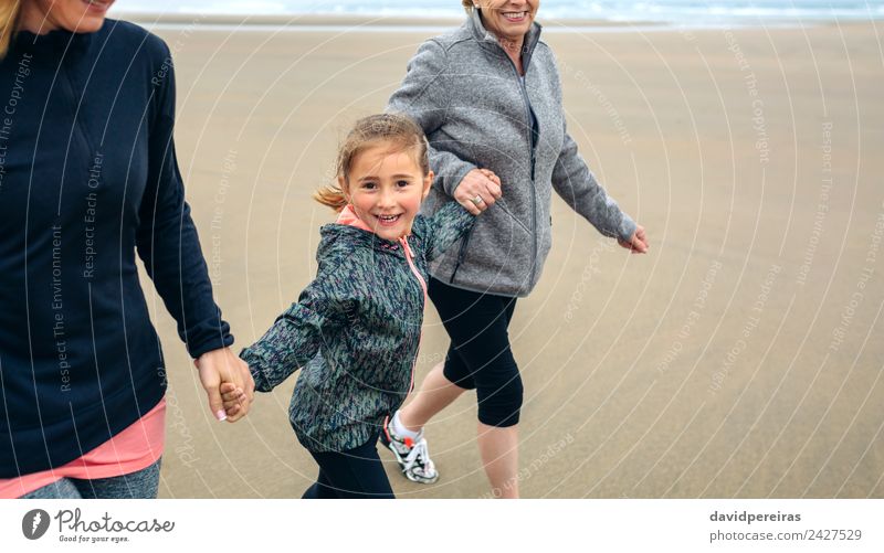 Kleines Mädchen läuft mit Frauen am Strand Lifestyle Freude Glück Spielen Kind Mensch Erwachsene Mutter Großmutter Familie & Verwandtschaft Sand Herbst Nebel