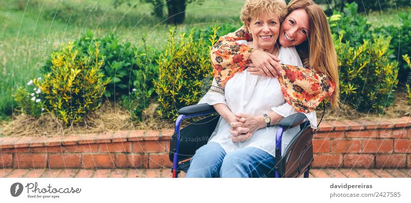 Tochter umarmt ältere Mutter im Rollstuhl Lifestyle Glück Gesundheitswesen Erholung Garten Mensch Frau Erwachsene Großmutter Familie & Verwandtschaft Natur