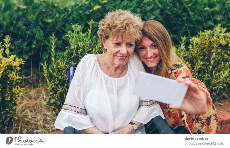 Frau nimmt Selfie mit älterer Mutter im Rollstuhl Lifestyle Glück Gesundheitswesen Erholung Garten PDA Mensch Erwachsene Großmutter Familie & Verwandtschaft