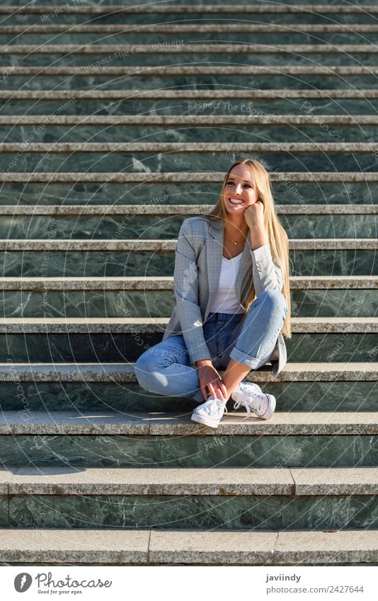 Blonde Frau lächelnd im urbanen Hintergrund Lifestyle Stil Glück schön Haare & Frisuren Mensch Erwachsene Herbst Straße Mode Bekleidung Jeanshose Jacke blond