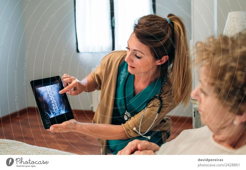 Ärztin, die ein Röntgenbild auf der Tablette zeigt. Krankheit Medikament Arzt Krankenhaus Mensch Frau Erwachsene alt authentisch erklären Knochenscan Stachel