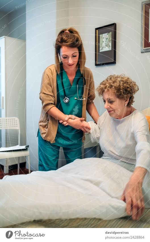 Pflegekraft hilft einer älteren Patientin beim Aufstehen aus dem Bett Lifestyle Gesundheitswesen Krankheit Medikament Arzt Krankenhaus Mensch Frau Erwachsene