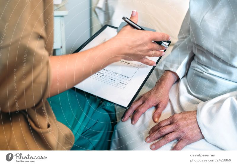 Ärztin beim Ausfüllen eines Fragebogens Gesundheitswesen Krankheit Medikament Arzt Krankenhaus Mensch Frau Erwachsene Hand Schreibstift alt sitzen authentisch