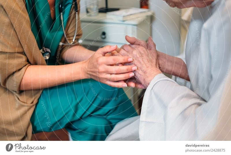 Ärztin hält Hand eines älteren Patienten Krankheit Medikament Arzt Krankenhaus sprechen Mensch Frau Erwachsene alt authentisch Freundlichkeit Vertrauen